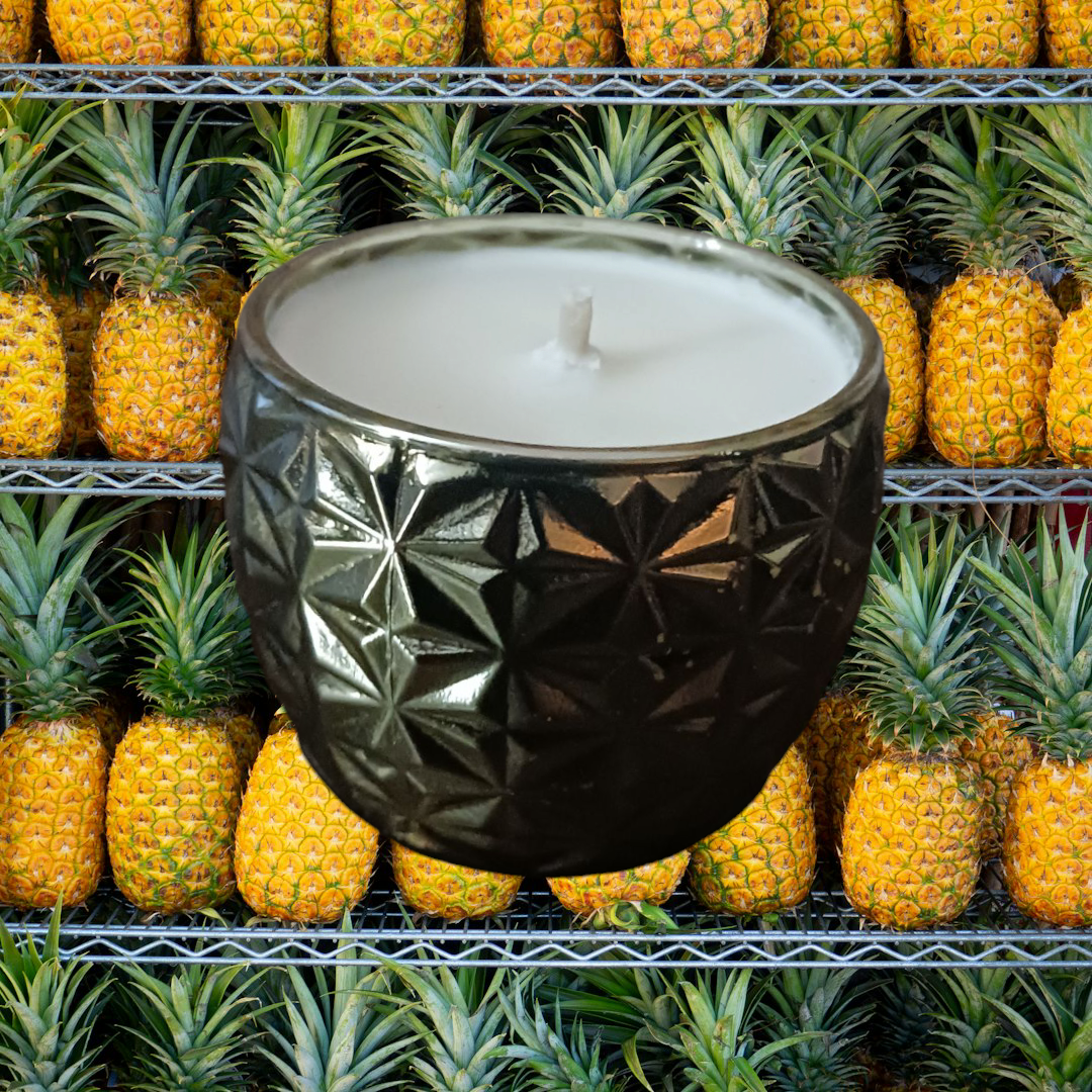 Luxury natural soy candle 7oz in a black textured ceramic container with pineapples in the background