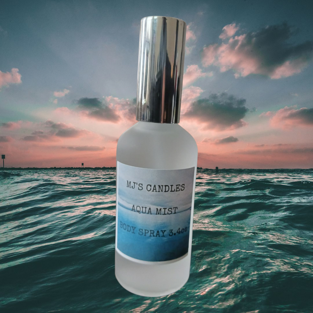 MJ'S CANDLES LLC fresh ocean scented body spray Aqua Mist bottle with silver cap over ocean background