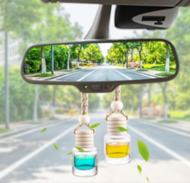 Cranberry cider car freshener hanging from rearview mirror with natural leaves floating around
