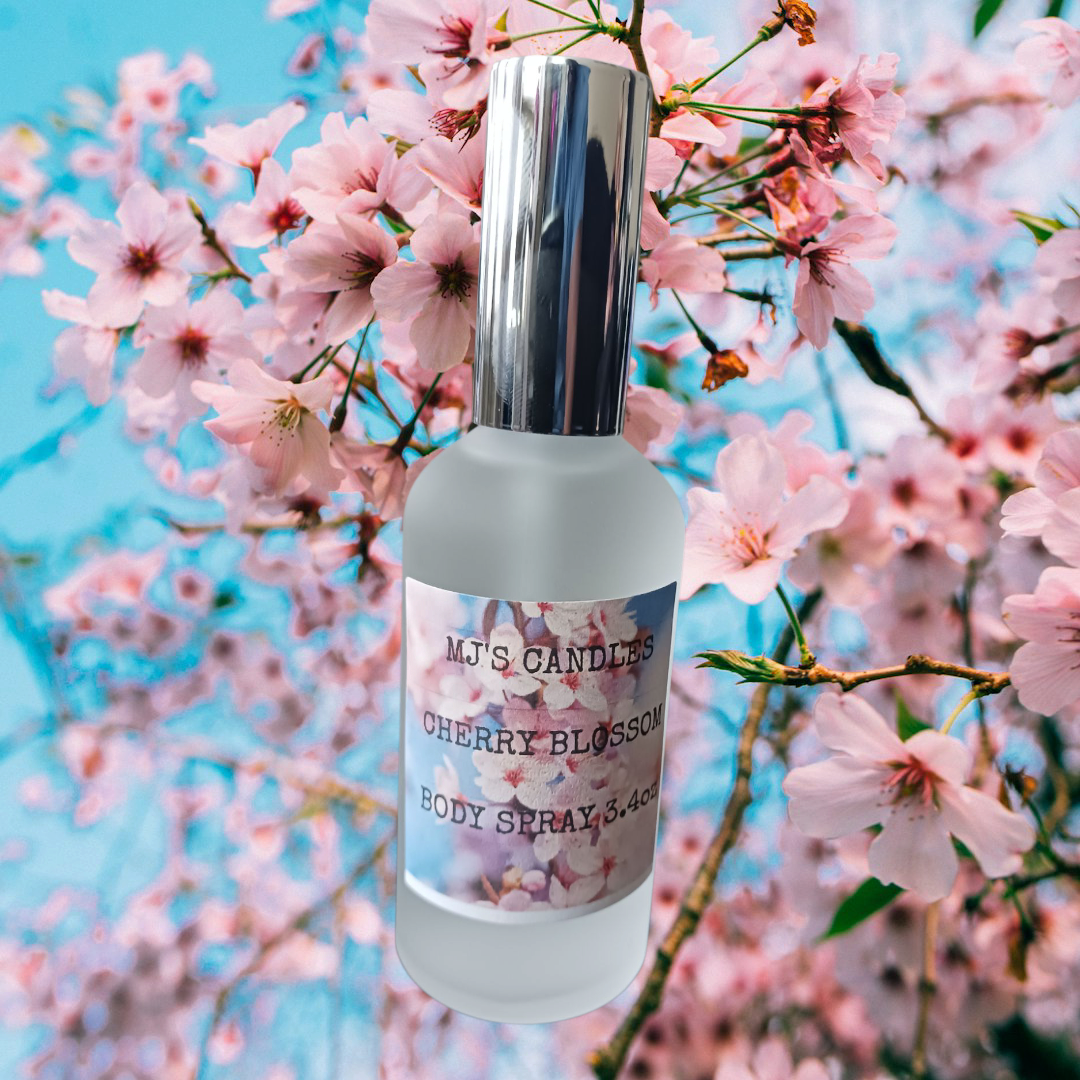 MJ'S CANDLES LLC cherry blossom body spray bottle with silver cap against pink cherry blossom flowers background