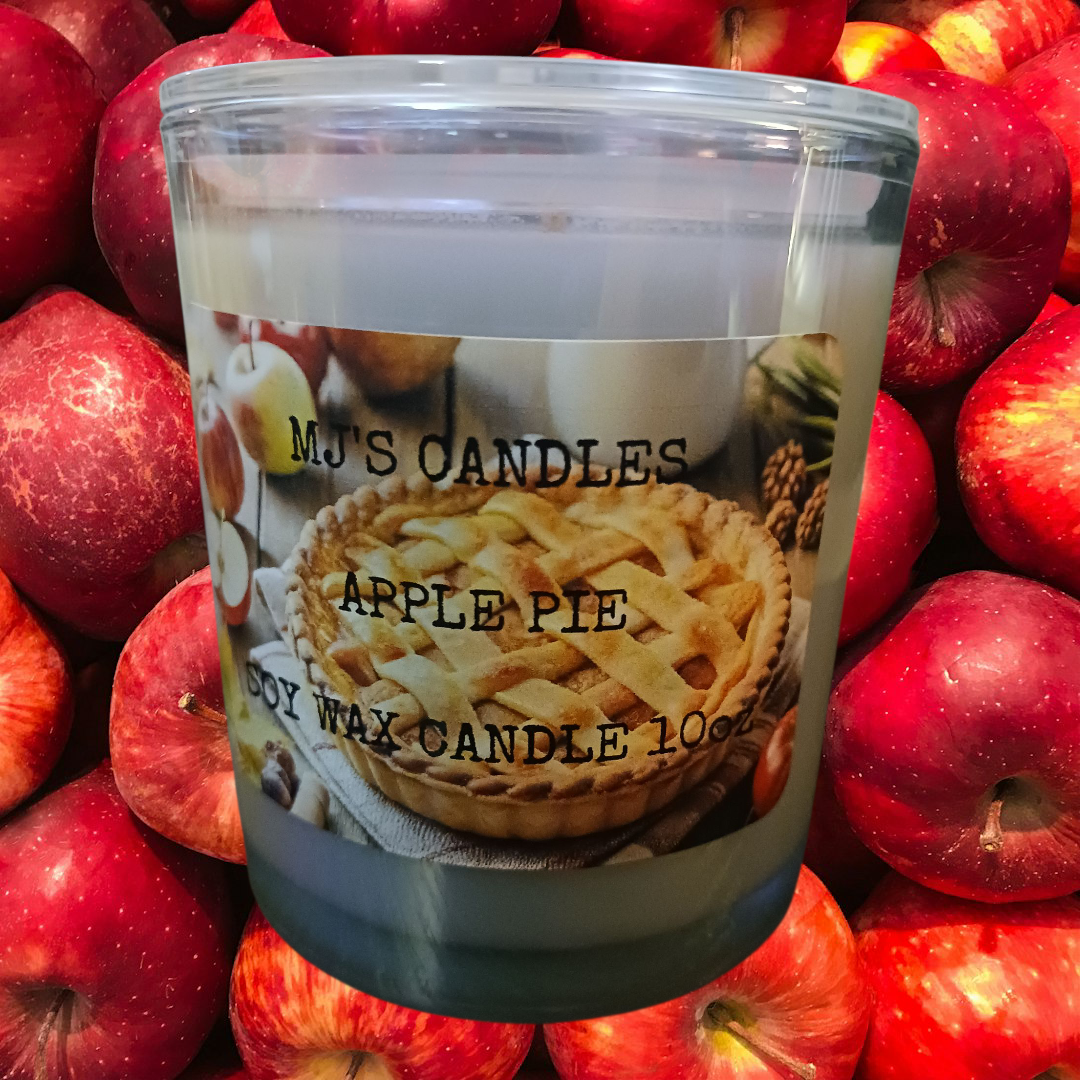 MJ'S CANDLES LLC handcrafted apple pie candle in clear glass jar with apple pie label surrounded by fresh red apples