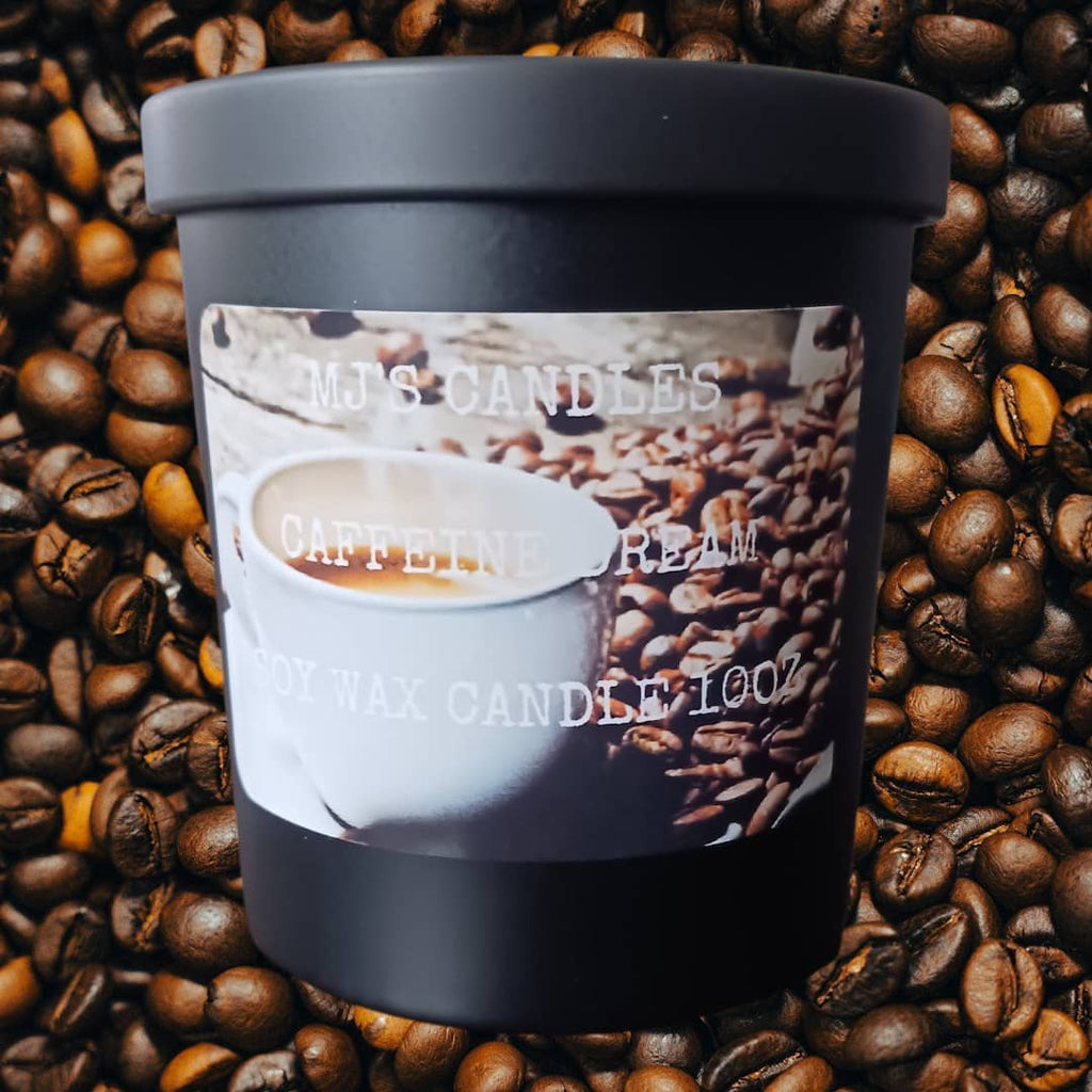 Black container coffee scented soy candle by MJs Candles surrounded by coffee beans