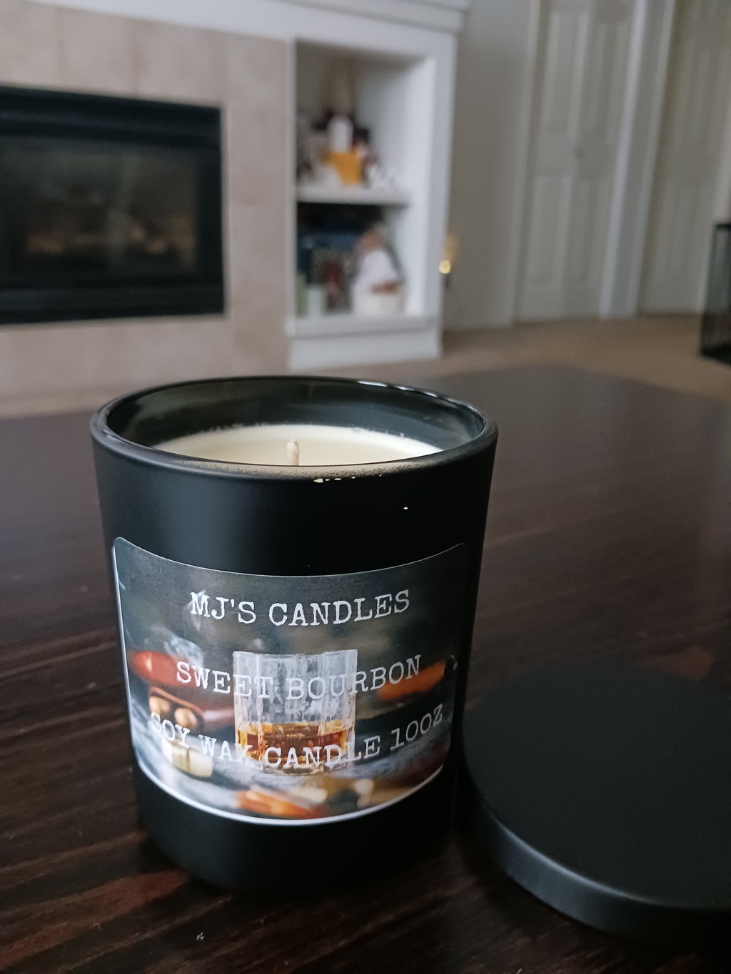 MJ'S CANDLES LLC handcrafted luxury soy candle in black jar with Sweet Bourbon label on wooden table