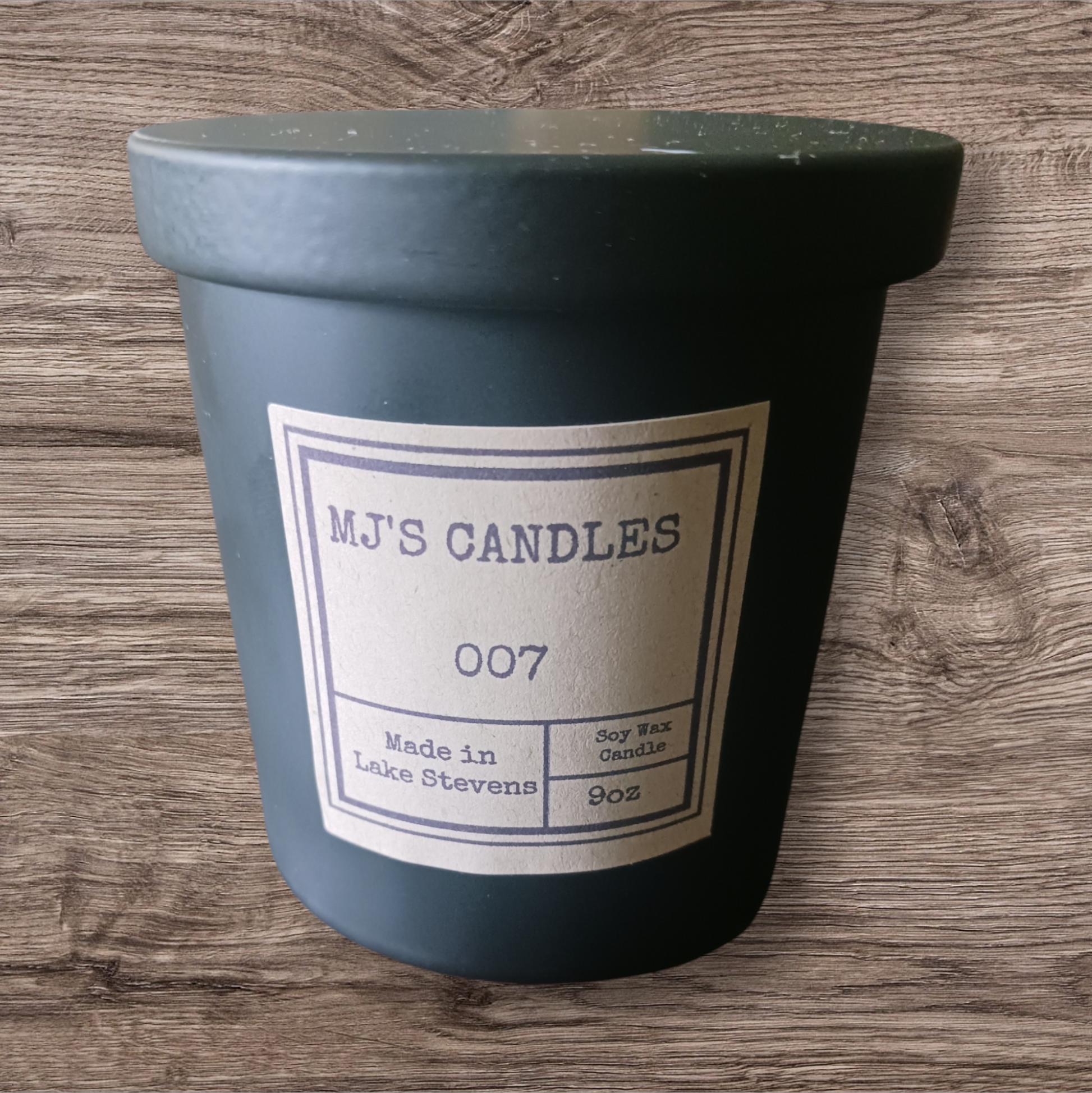 MJ'S CANDLES luxury soy candle in matte black jar with lid and minimalist label on wooden background