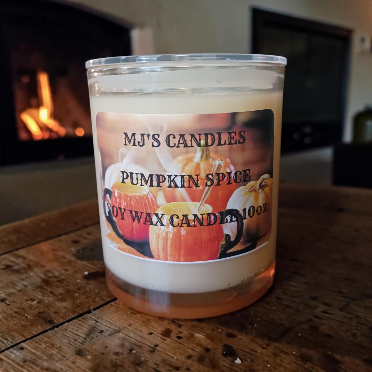 MJ'S CANDLES Pumpkin Spice soy wax candle in glass jar on wooden table near fireplace
