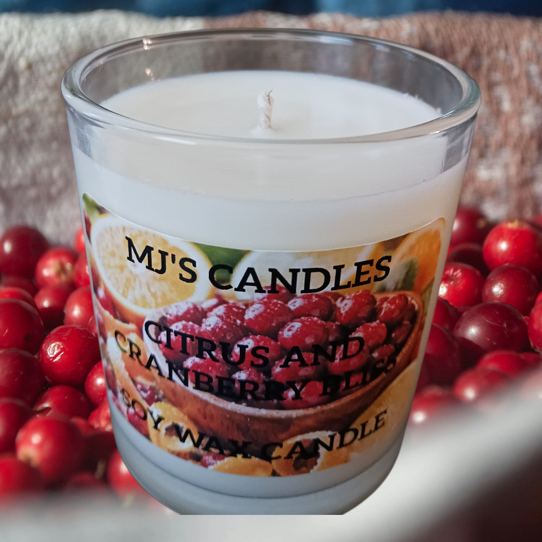 MJ'S CANDLES LLC citrus and cranberry blend soy candle in clear glass jar surrounded by fresh cranberries