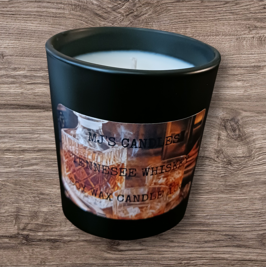 MJ's Candles Tennessee whiskey scented soy wax candle in a black glass holder on wood surface